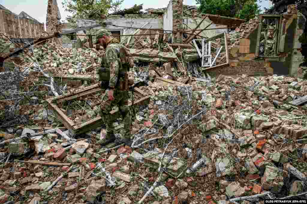 A Ukrainian soldier walks amid the ruins of a building destroyed by Russian missile strikes in the Donetsk region.