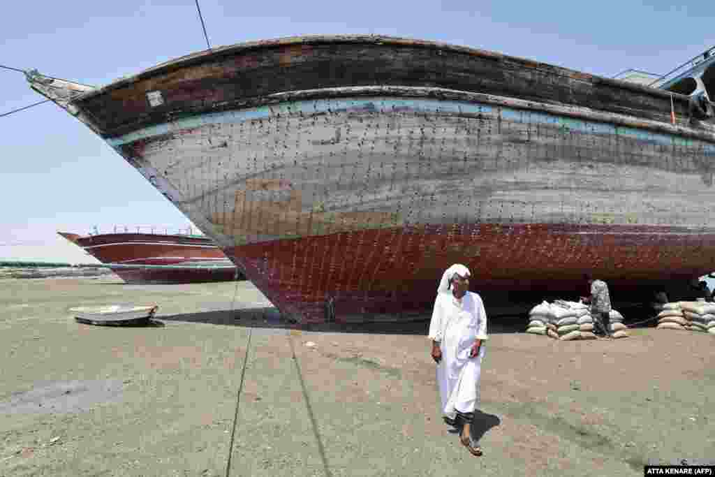 A man walks in front of a traditional Iranian lenj boat that awaits restoration on Iran&#39;s Qeshm Island on April 29. The silhouette of these hand-built wooden vessels is as much a part of the maritime landscape of the Middle East as that of the sailing dhows of the Arabian Peninsula. &nbsp; 