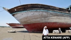 <div>A man walks in front of a traditional Iranian lenj boat that awaits restoration on Iran&#39;s Qeshm Island on April 29. The silhouette of these hand-built wooden vessels is as much a part of the maritime landscape of the Middle East as that of the sailing dhows of the Arabian Peninsula.</div>
<div>&nbsp;</div>
