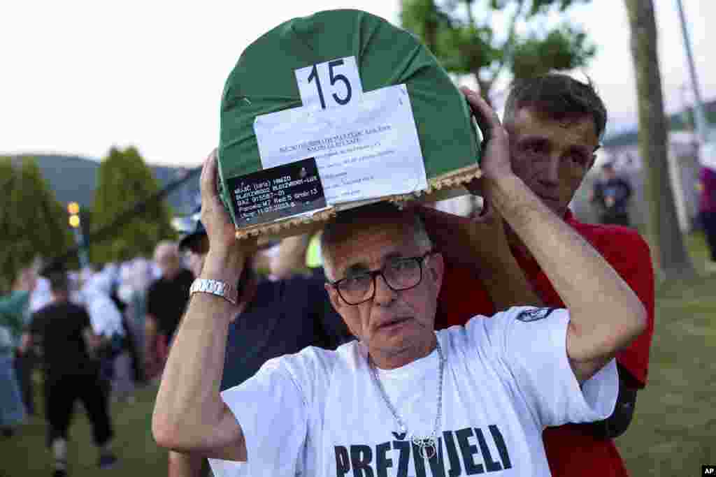 Muslim men carry coffins containing the remains of their recently identified relatives that were interned on July 11.