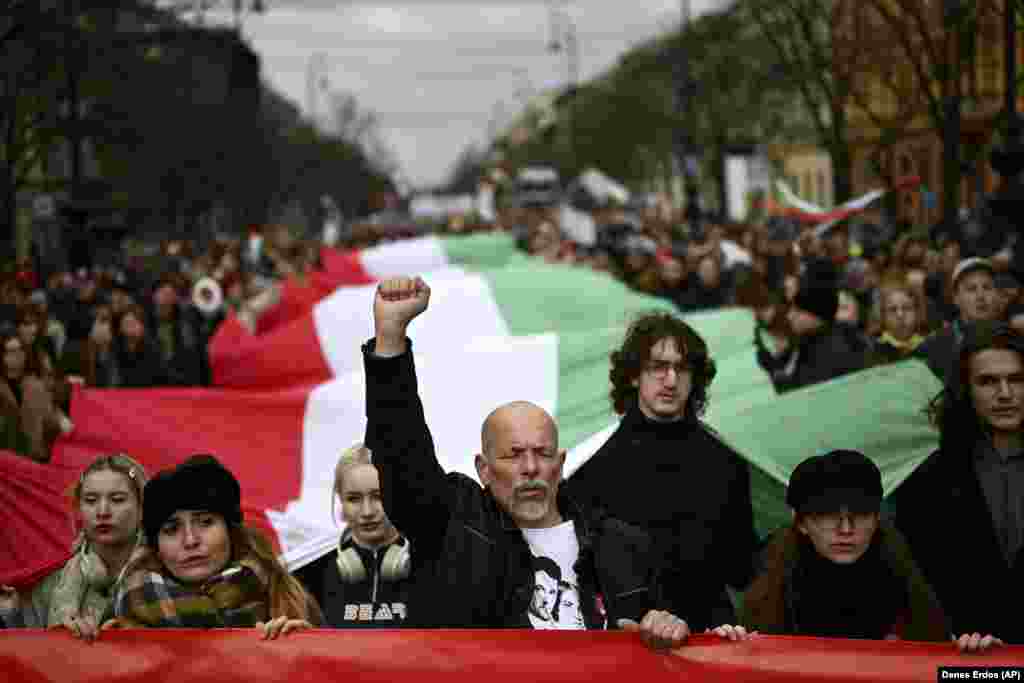 Protesters carry a large Hungarian flag as they take part in an anti-government demonstration in Budapest on March 15. Organized by teachers&#39; unions and student groups, the peaceful &quot;freedom march&quot; called for educational reforms and a change of direction for Hungary&#39;s political future.&nbsp;&nbsp; 