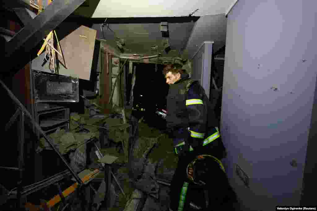 A rescuer inspects a damaged apartment following the attack.