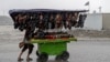 An Afghan vendor pushes a cart of footwear through a street as it rains in Kabul on May 23. 