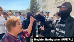 A woman addresses a policeman outside the Almaty court following the sentencing of five people on July 11. The Kazakh public has been skeptical of the state investigation into the bloody violence that killed at least 238 people in January 2022.