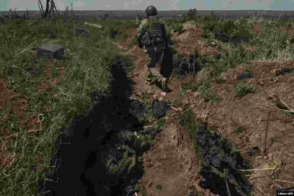A Ukrainian soldier walks along a recently captured Russian trench. Ukraine said on July 4 that its troops had regained more ground on the eastern and southern fronts, although Deputy Defense Minister Hanna Malyar said fighting had surged around the eastern city of Bakhmut, captured by Russian forces in May.