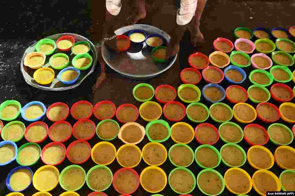 A Muslim devotee prepares bowls of iftar food at the Wallajah Mosque in Chennai, India. &nbsp;