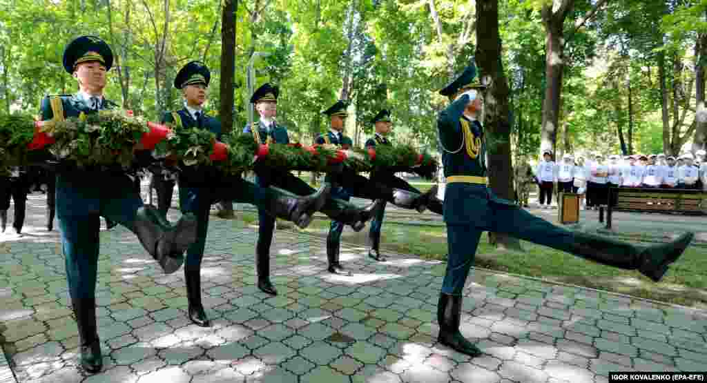 Soldiers from Kyrgyzstan&#39;s National Guard carry wreaths during a ceremony at the monument to fallen Chernobyl liquidators in Bishkek. Soviet authorities sent thousands of poorly equipped personnel called liquidators to clean up the ejected radioactive material. Many of them died as a result of their work often, suffering from various forms of cancer.