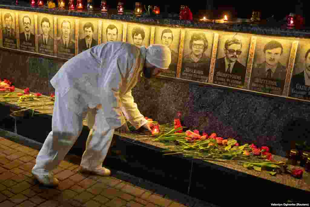 A worker from the Chernobyl power plant places a candle at a memorial in Slavutych, Ukraine, dedicated to firefighters and workers who died in the 1986 nuclear disaster. &nbsp;