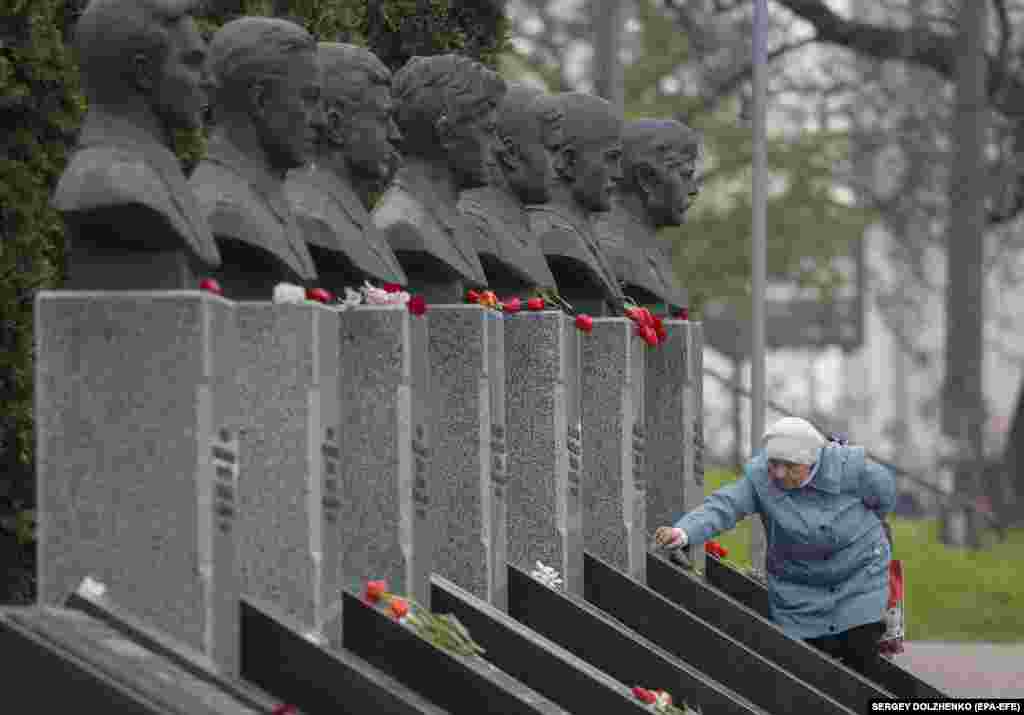 Another woman lays flowers at the memorial in Kyiv honoring those who died trying to clean up the radioactive debris from the Chernobyl accident.