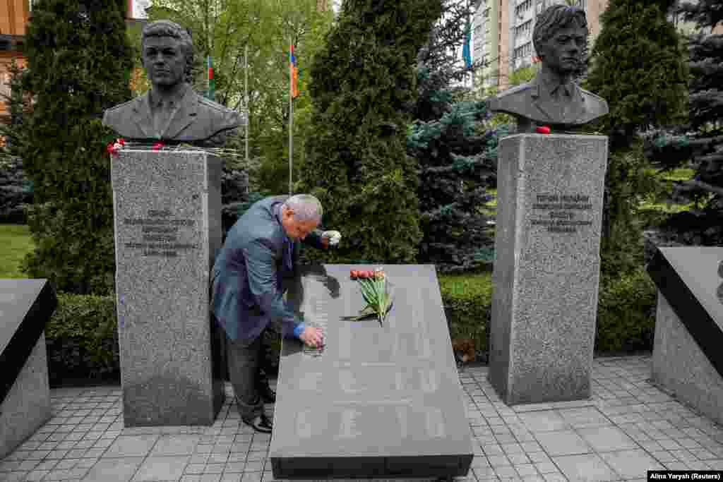 A man cleans a plaque&nbsp;at the Chernobyl memorial in Kyiv&nbsp;that contains the names of those who died in the disaster.