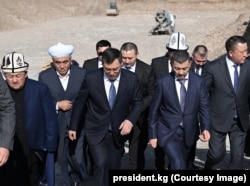 Kyrgyz President Sadyr Japarov (third from left) walks with Khabibula Abdukadyr (second from right) at the inauguration of a new mosque near Bishkek.