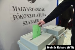 A voter drops off their ballot at the Hungarian consulate in Subotica, Serbia, on April 3.
