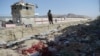 A Taliban fighter stands guard at the site of the August 26 twin suicide bombings that killed scores of people at Kabul airport in 2021.