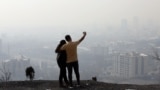 An Iranian couple takes a selfie as smog obscures the skyline in Tehran earlier this year. 