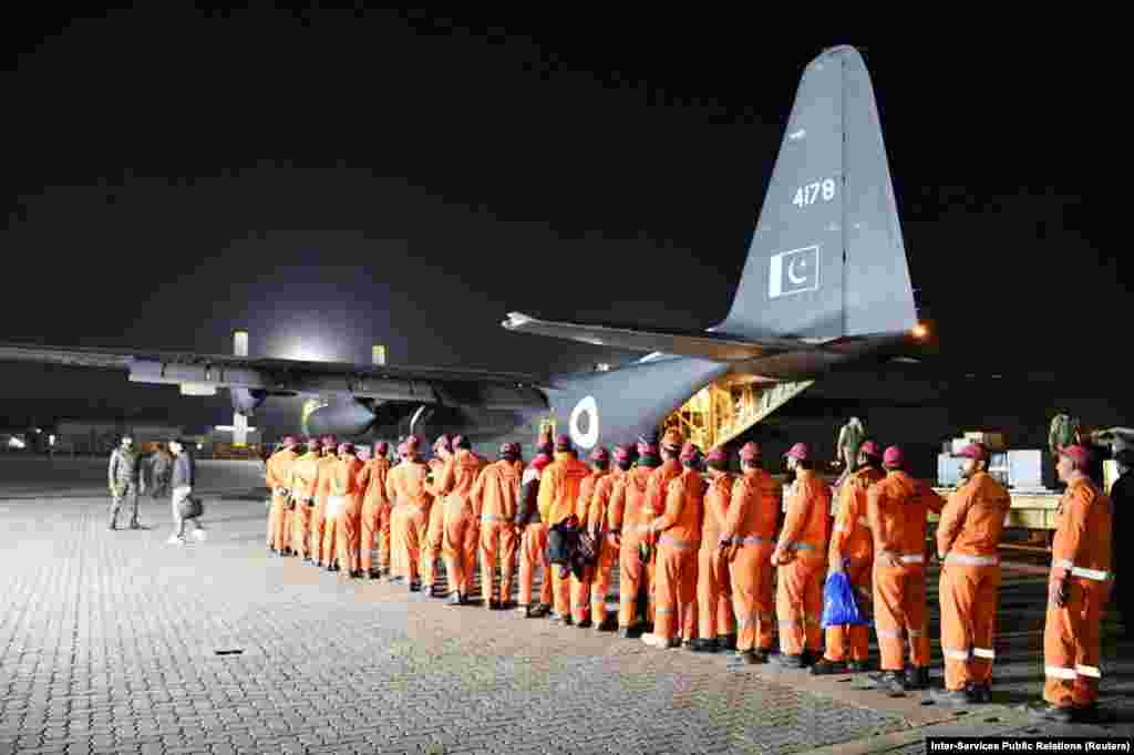 Members of a search-and-rescue team from the Pakistani military board an Air Force aircraft in Rawalpindi early on February 7. Two flights of rescue teams, as well as a mobile hospital and other equipment, were sent from Pakistan.&nbsp;