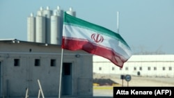 An Iranian flag flies at the Bushehr nuclear power plant, its first, during an official ceremony to kick-start work on a second reactor at the facility in 2019.
